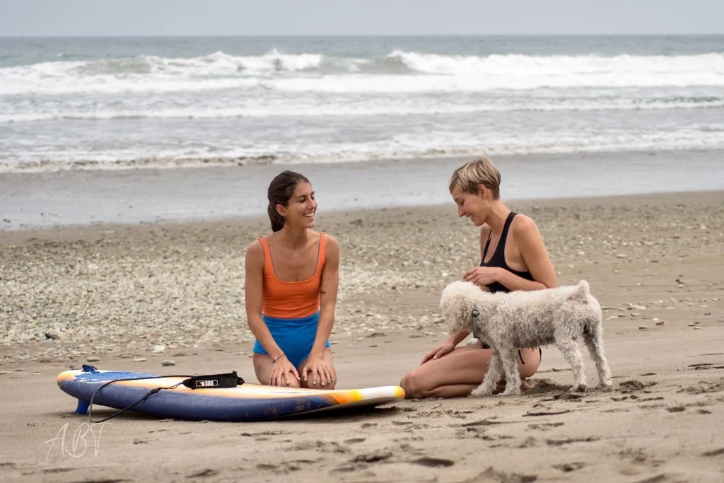 Female surf instructor guiding a beginner surfer in Ecuador.