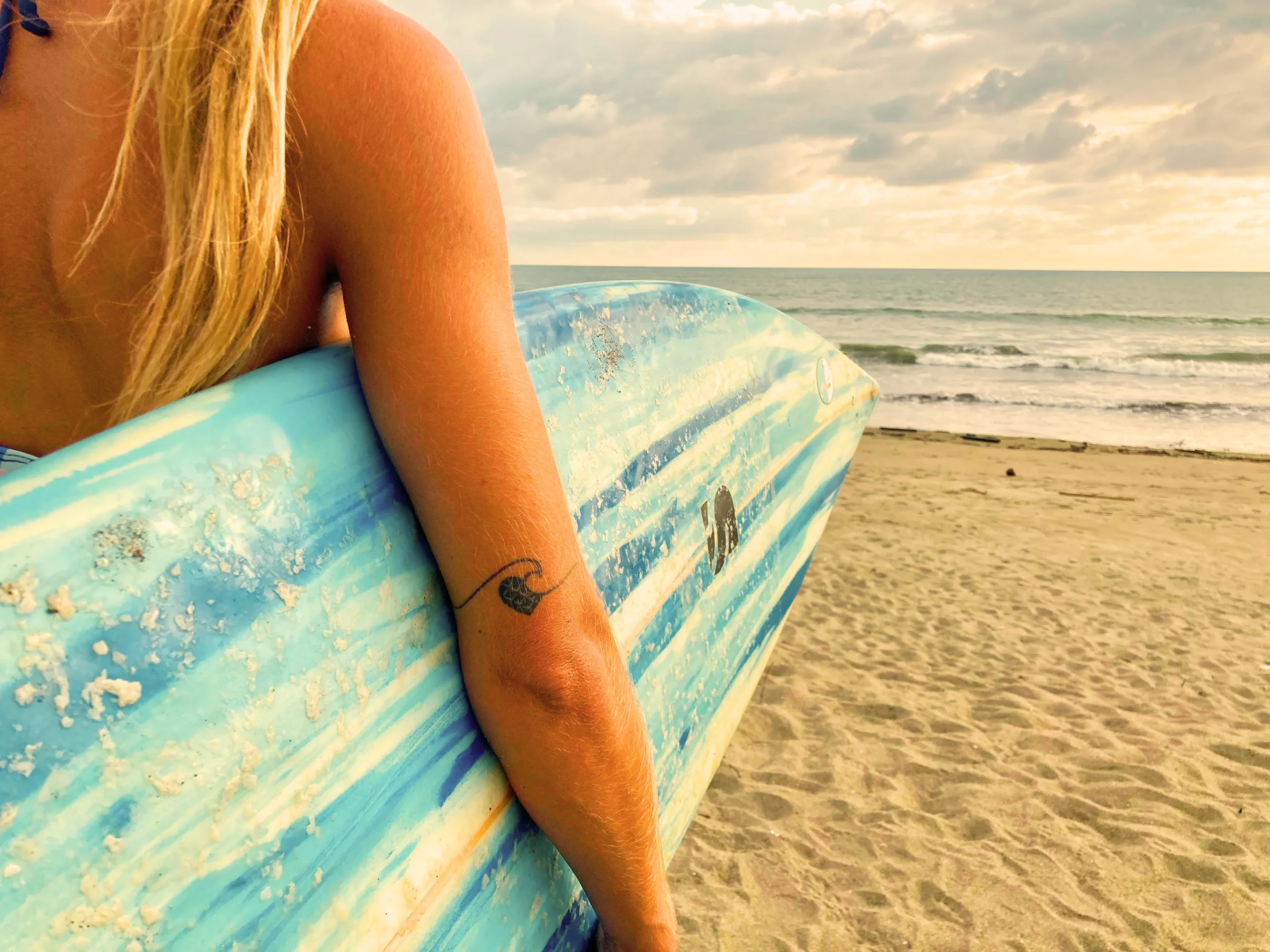 woman holding a surfboard ready for the surf season in Ecuador