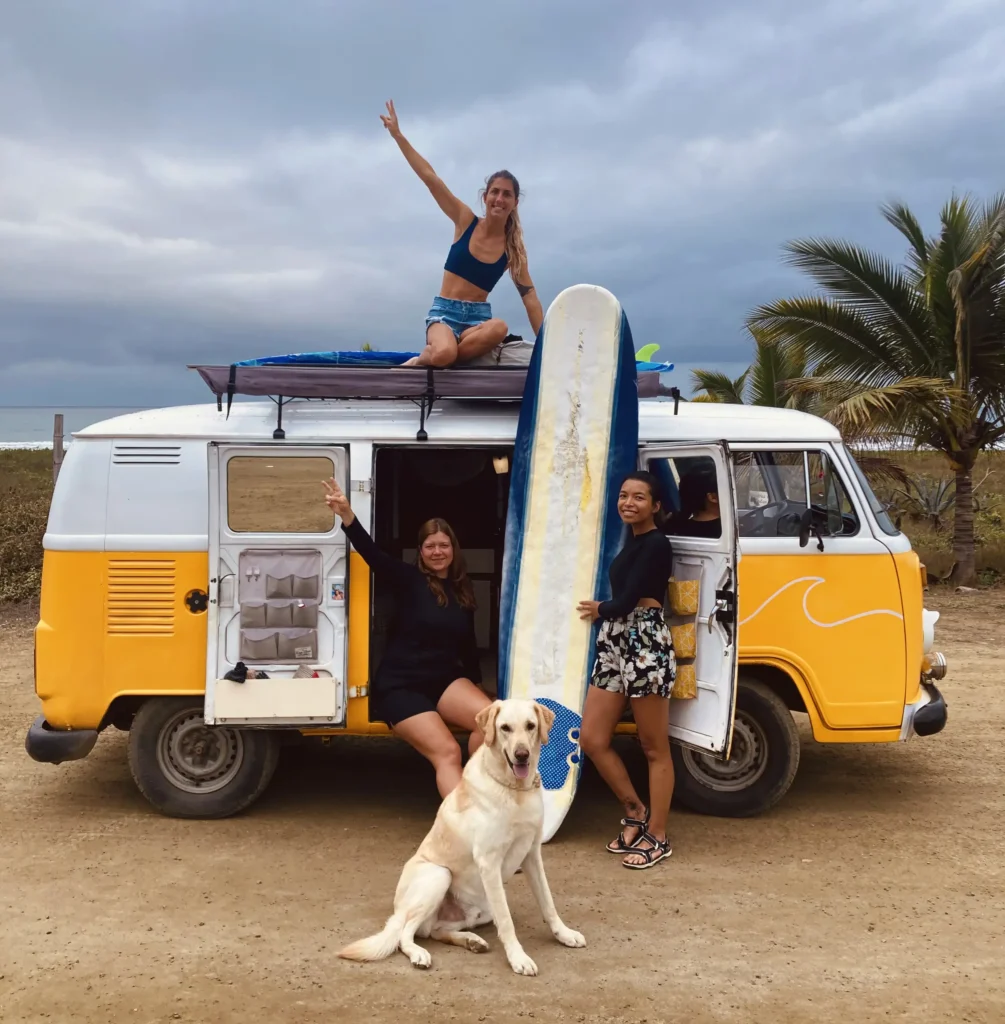 Three women traveling in a van with surfboards during a women’s surf trip in Ecuador.